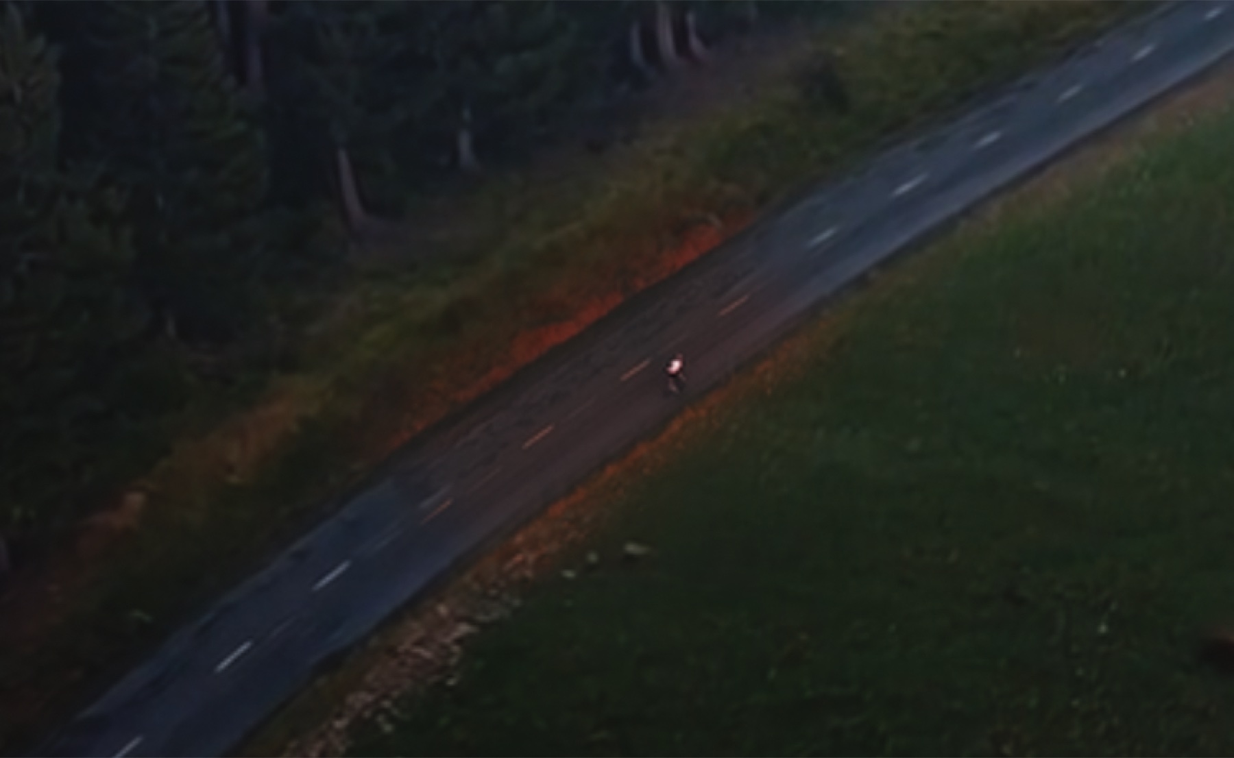 The sunset-colored cyclist patch sitting on top of the cool overcast AI road. The orange warmth of the original reads as obviously out of place.